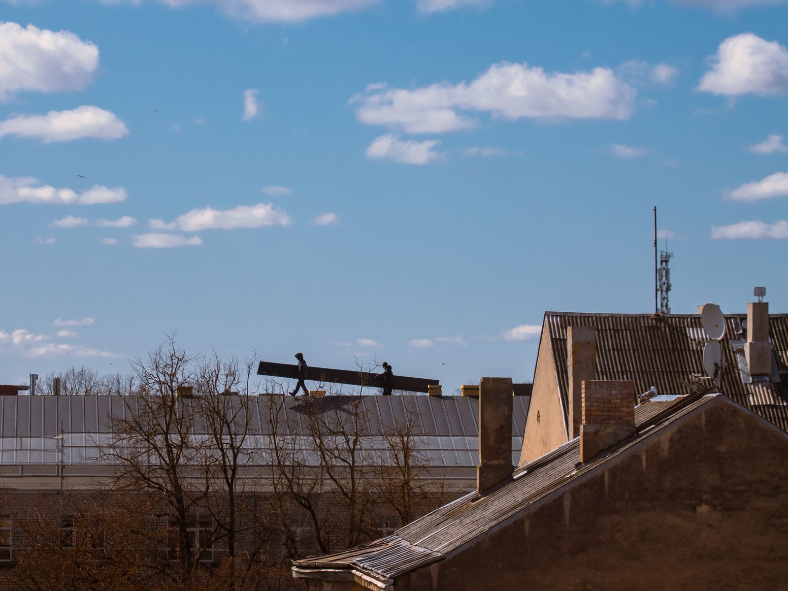 Roofer installing shingles on a rooftop